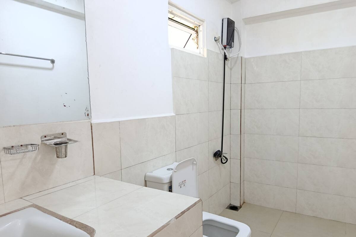 A bathroom with a toilet, bidet, and a shower.