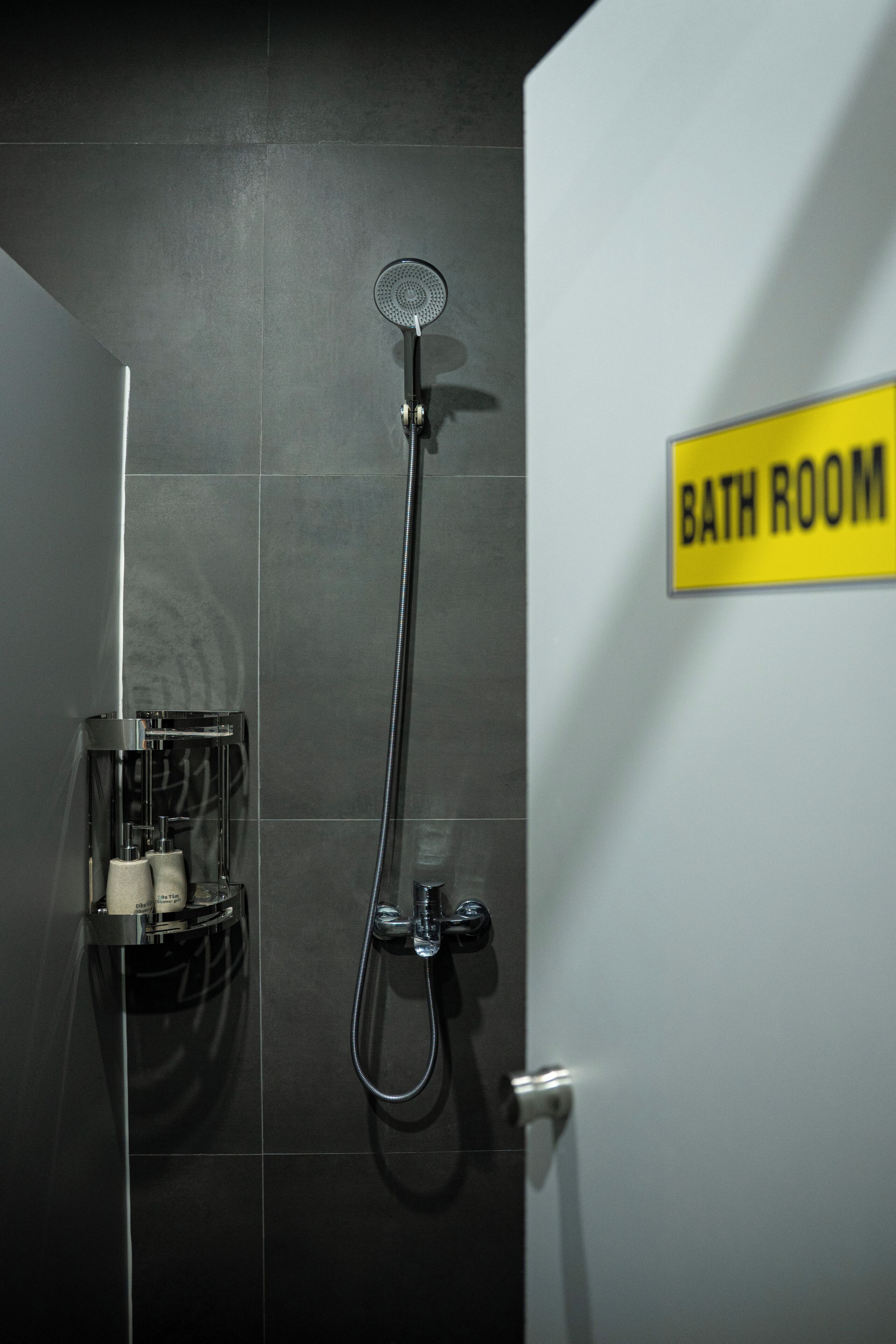 A bathroom with a shower, a glass enclosure, and a sign indicating it's a bathroom.