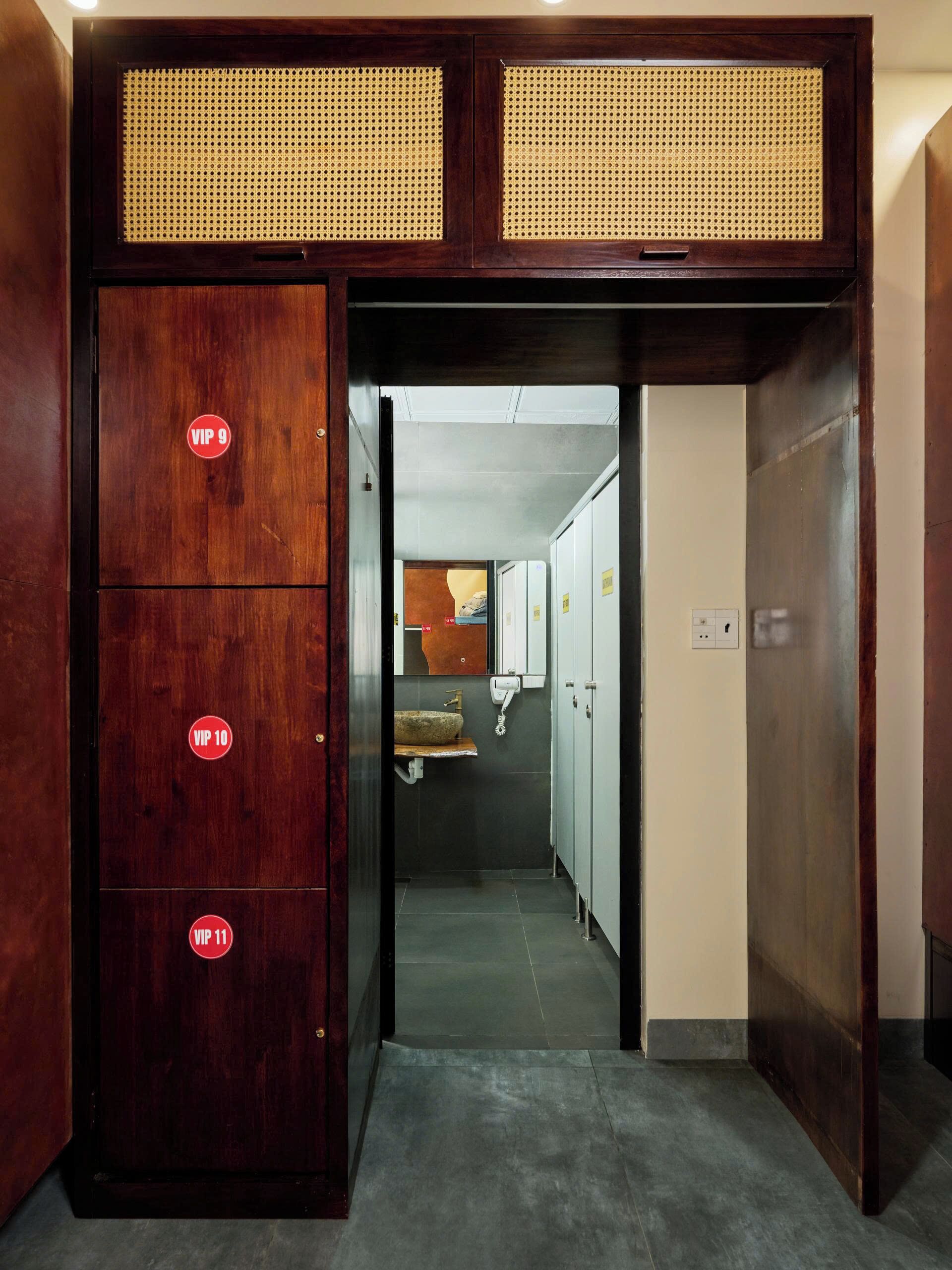 Una habitación de hotel con un armario de madera, un baño con lavabo y un espejo.