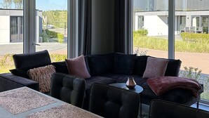 A modern kitchen with a built-in island, large windows, and a view of the outside. - Noordzee Deluxe 32 by Interhome (Scherpenisse)