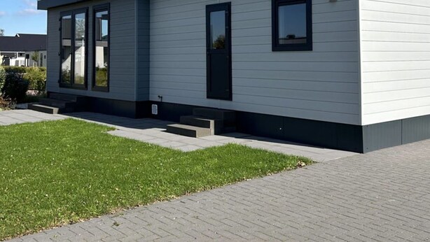 A modern single-story building with a flat roof, large windows, and a small front porch. - Noordzee Deluxe 32 by Interhome (Scherpenisse)