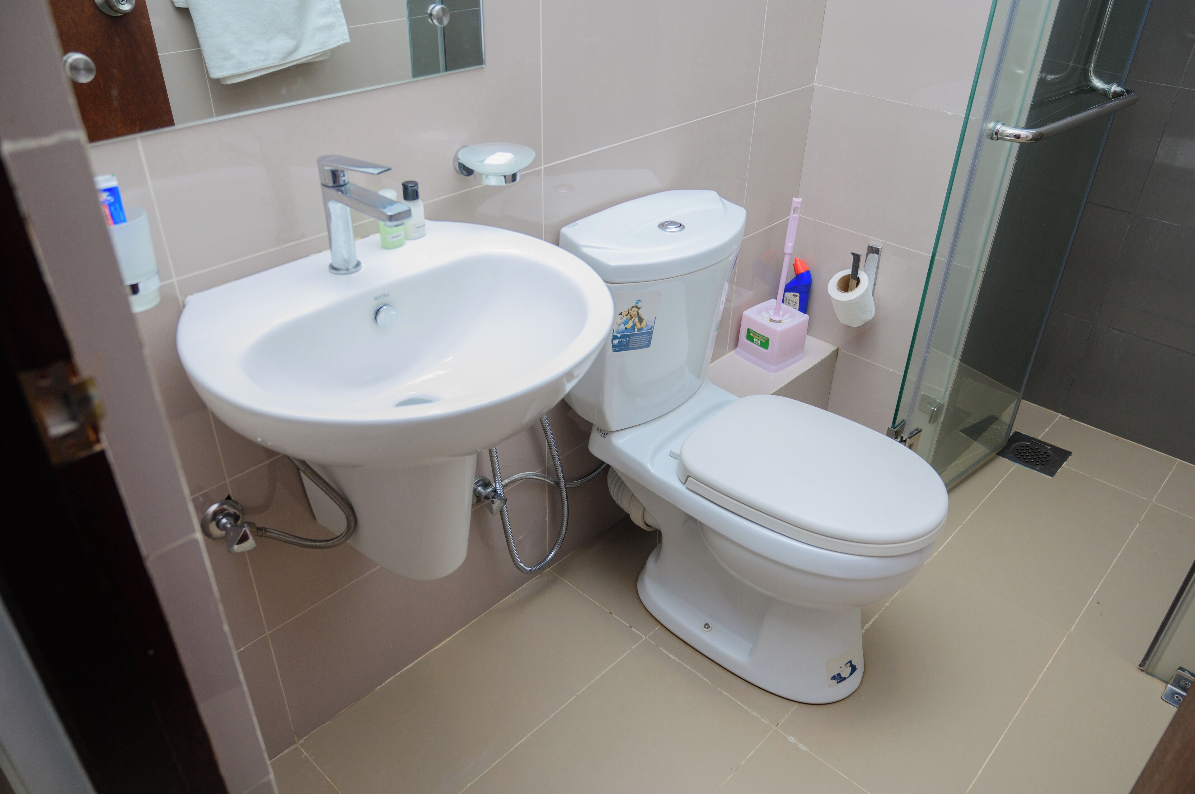 A bathroom with a sink, toilet, and glass shower enclosure.
