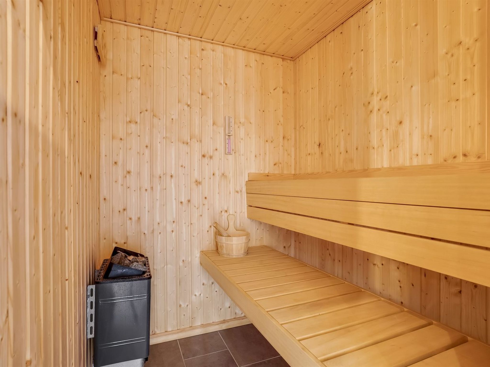 A sauna room with wooden walls and benches.