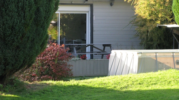 A backyard with a covered patio table, a small bush with red leaves, and a large tree. - Gîte 10 minutes from the beach (Hudimesnil)
