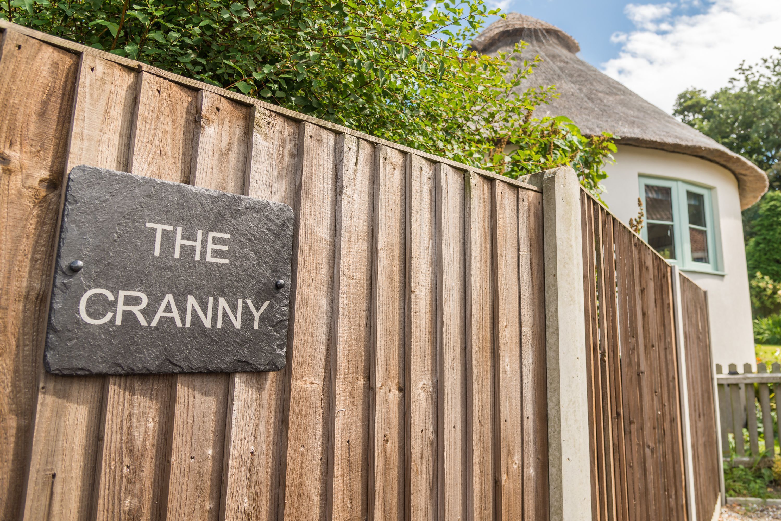 Una valla de madera con un letrero que dice "THE CRANNY".
