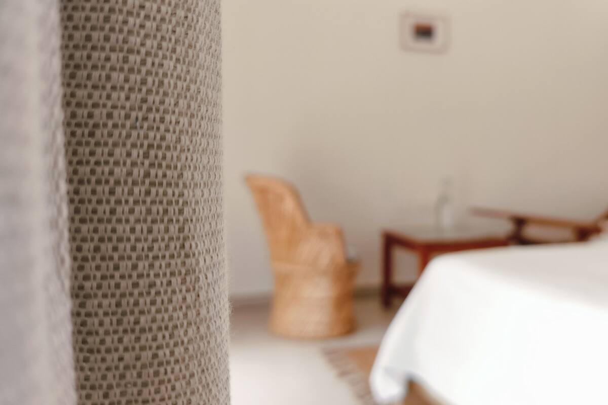 A room with a bed, a chair, and a small table.