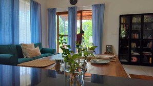 Una sala de estar con un sofá verde, una mesa de centro y una estantería.