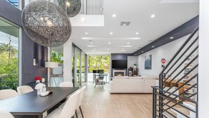 Una sala de estar moderna con comedor, chimenea y escalera.
