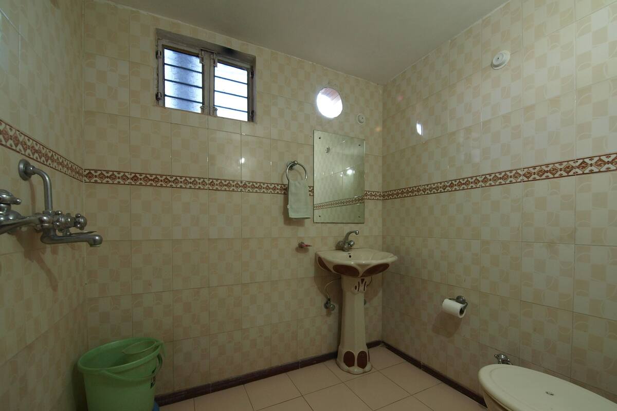 Une salle de bain avec des toilettes, un lavabo et une douche.