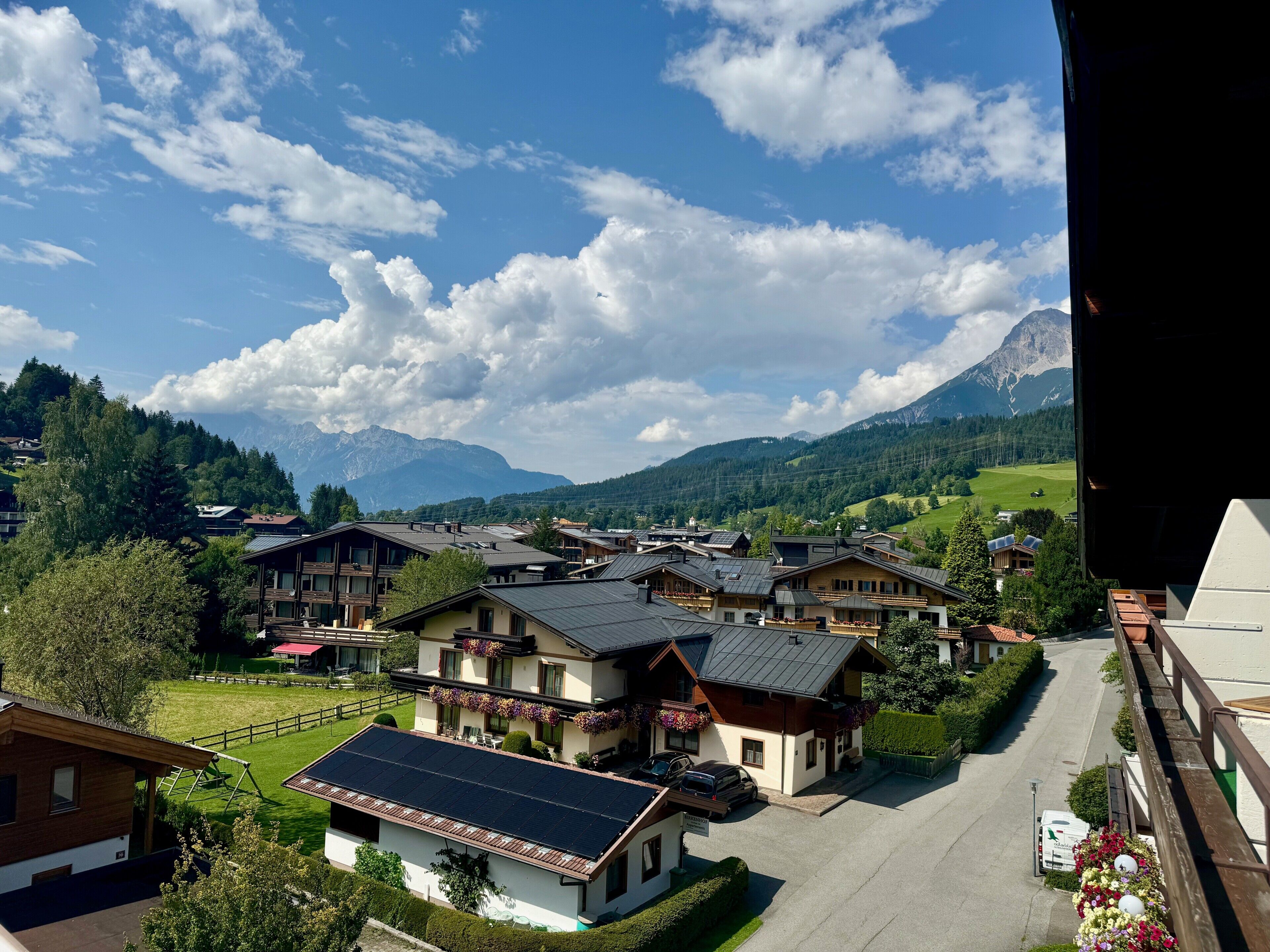 Ein Wohngebiet mit Häusern, einer Straße und Bergen im Hintergrund.