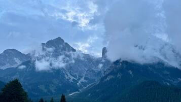 Een berglandschap met een opvallende bergtop, beboste valleien en een heldere lucht.