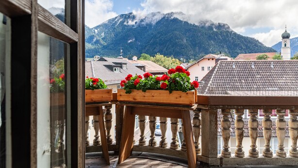A balcony with wooden railings and flower boxes. - Guest Rooms "König-Max-ll" and "Ludwig-Thoma" (Oberammergau)