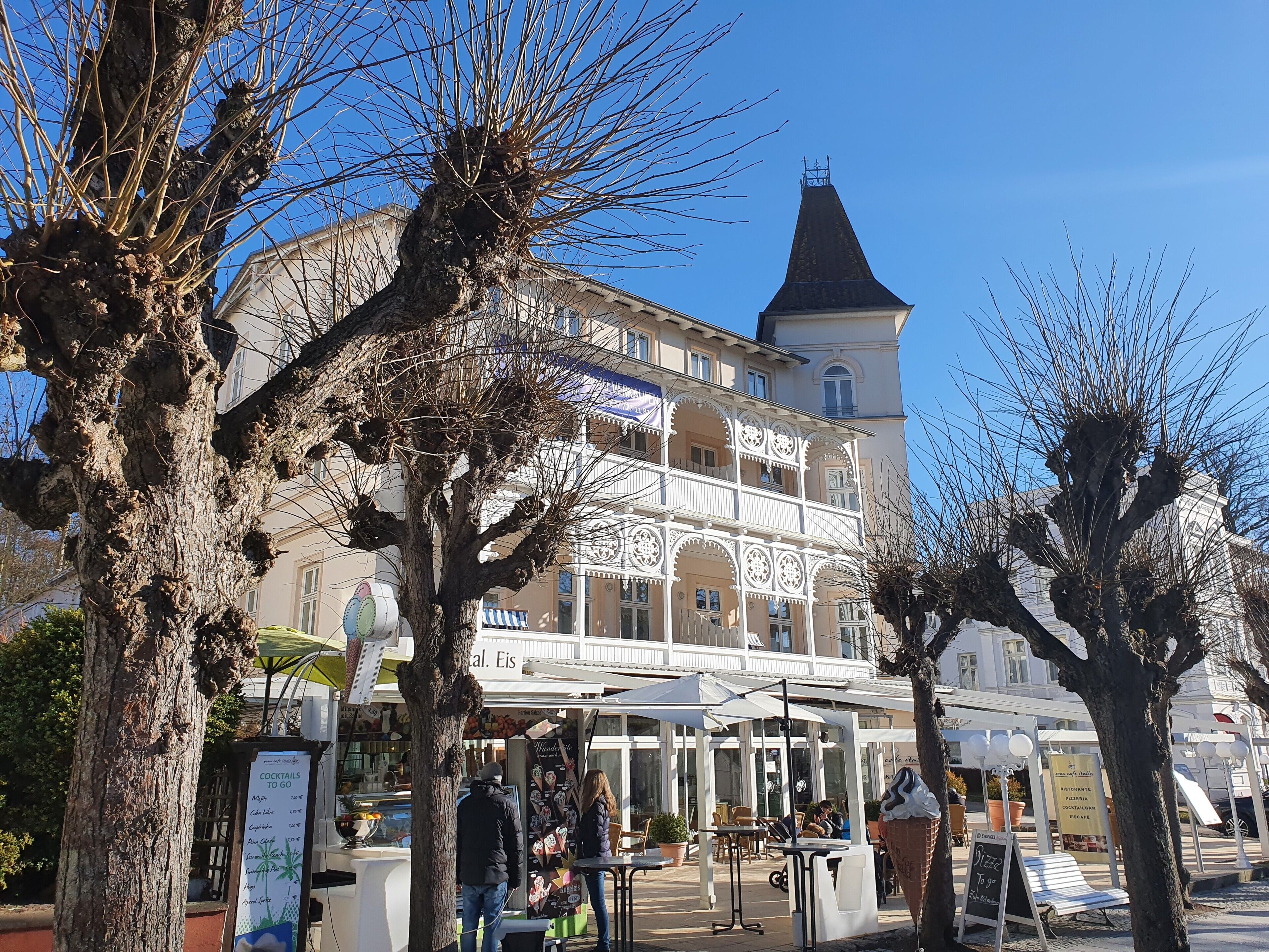 A building with a tower, outdoor seating, and a menu board.