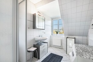 Un bagno moderno con lavandino, specchio e finestra.