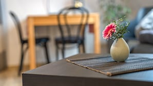 A dining table with a vase of flowers, a placemat, and a chair in the background. - Haus Ursula, Double Room with Wi-Fi (Ettenheim)