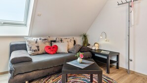 A modern living room with a sofa, a coffee table, a floor lamp, and a TV antenna. - Haus Ursula, Double Room with Wi-Fi (Ettenheim)