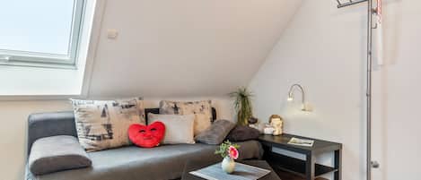 A modern living room with a sofa, a coffee table, a floor lamp, and a TV antenna.