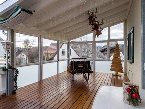 A spacious room with large windows, a wooden floor, a fireplace, and a Christmas tree. - Room 'Zimmer 10' with Shared Terrace, Shared Garden and Wi-Fi (Ebenweiler)