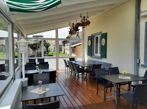 An outdoor patio with tables and chairs, a wooden ceiling, and a view of the surrounding area. - Room 'Zimmer 9' with Shared Terrace, Shared Garden and Wi-Fi (Ebenweiler)