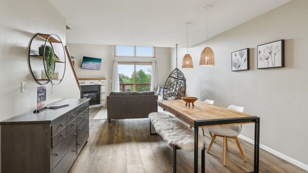 Een modern appartement met een eethoek, een bank, een open haard en uitzicht op het omliggende landschap.