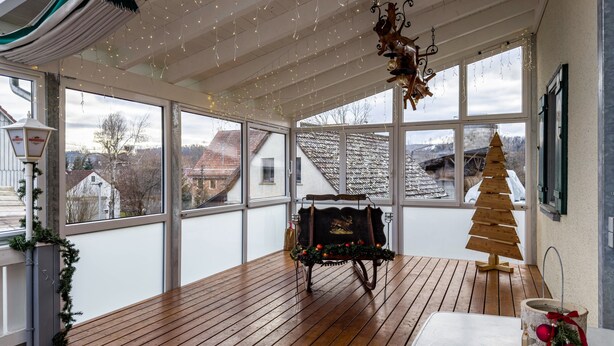 A spacious room with large windows, a wooden floor, a fireplace, and a Christmas tree. - Room 'Zimmer 8' with Shared Terrace, Shared Garden and Wi-Fi (Ebenweiler)