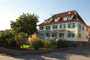 Un bâtiment à deux étages doté d’un balcon, d’une enseigne indiquant qu’il s’agit d’un restaurant, et d’une clôture entourant la propriété.