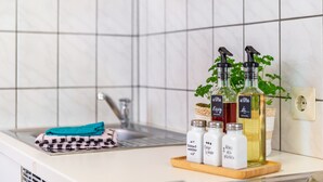 A kitchen counter with a sink, a folded towel, and bottles of liquid soap and oil.