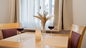 Un tavolo da pranzo con due sedie, una candela e un vaso con piante essiccate.