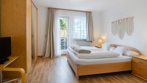 Camera da letto con un letto, comodino, lampada, tende e televisore.