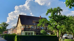 A two-story house with a sloped roof, a visible chimney, and a well-maintained hedge. - Studio Apartment 'Nr 6' with Shared Terrace, Shared Garden and Wi-Fi (Bad Dürrheim)