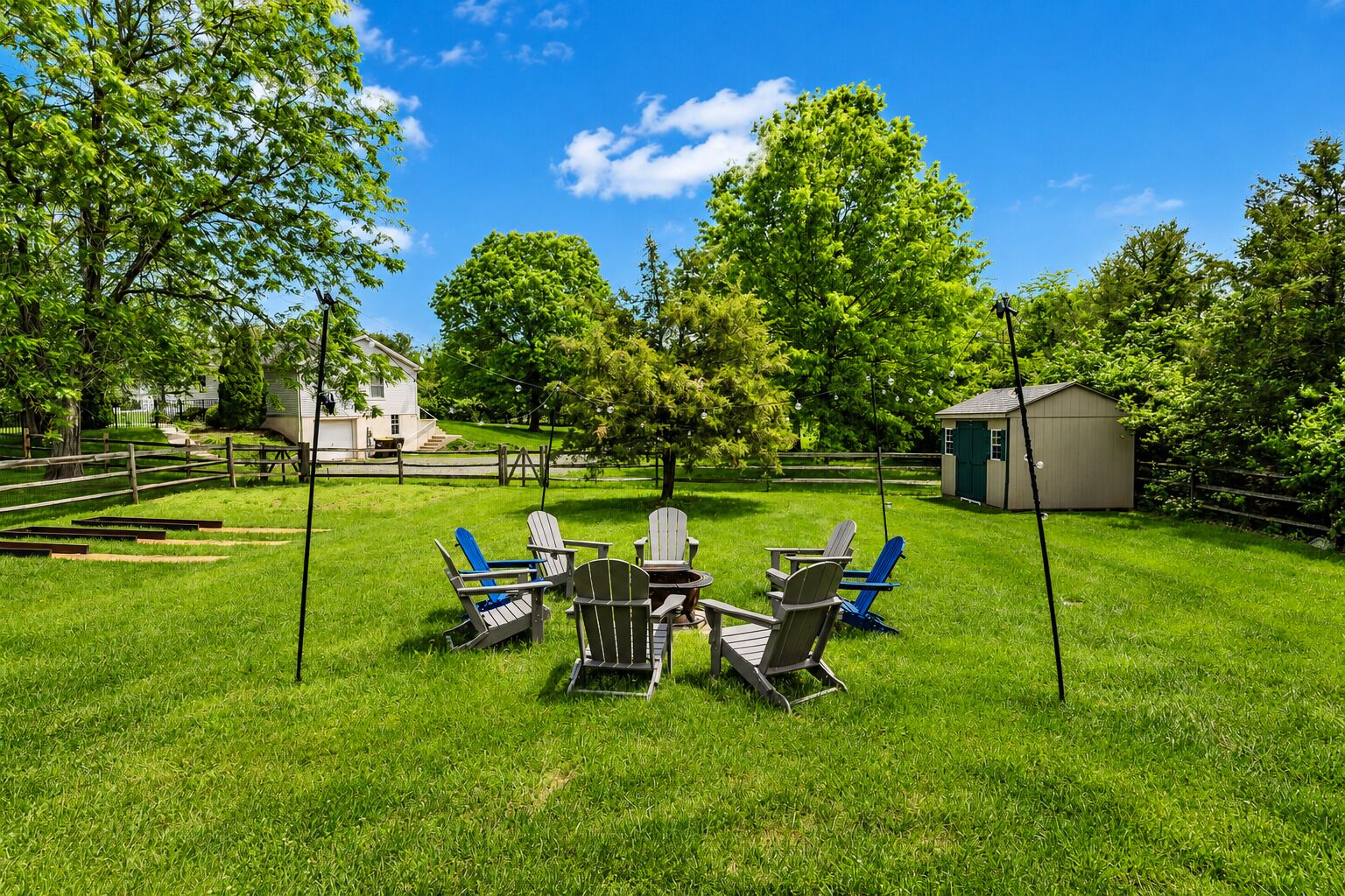 Ein Garten mit Rasen, Holzzaun und Gartenhaus.