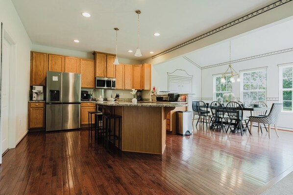 A spacious kitchen with wooden cabinets, stainless steel appliances, and a central island.