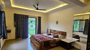 A modern bedroom with a large bed, bedside tables, and a ceiling fan.
