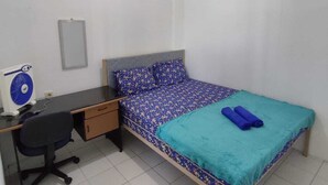 Una camera da letto con un letto, una scrivania, una sedia e un tavolino.