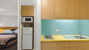 A compact kitchenette with a microwave, refrigerator, and sink. - The Entrance Waterfront Resort, Unit 614 (The Entrance)