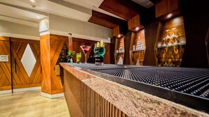 A bar area with a wooden counter, a minibar, and a wall with decorative glassware. - Zip By Spree Hotels Kolhapur (Kolhapur)