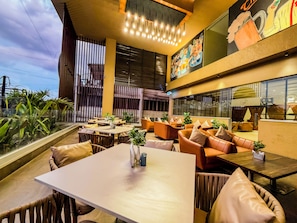 A restaurant with outdoor seating, tables, and chairs. - Zip By Spree Hotels Kolhapur (Kolhapur)
