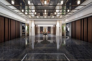A spacious lobby with a polished marble floor, a central table with decorative items, and a modern ceiling design. - CHUNHUA TIMELESS (Guangzhou)