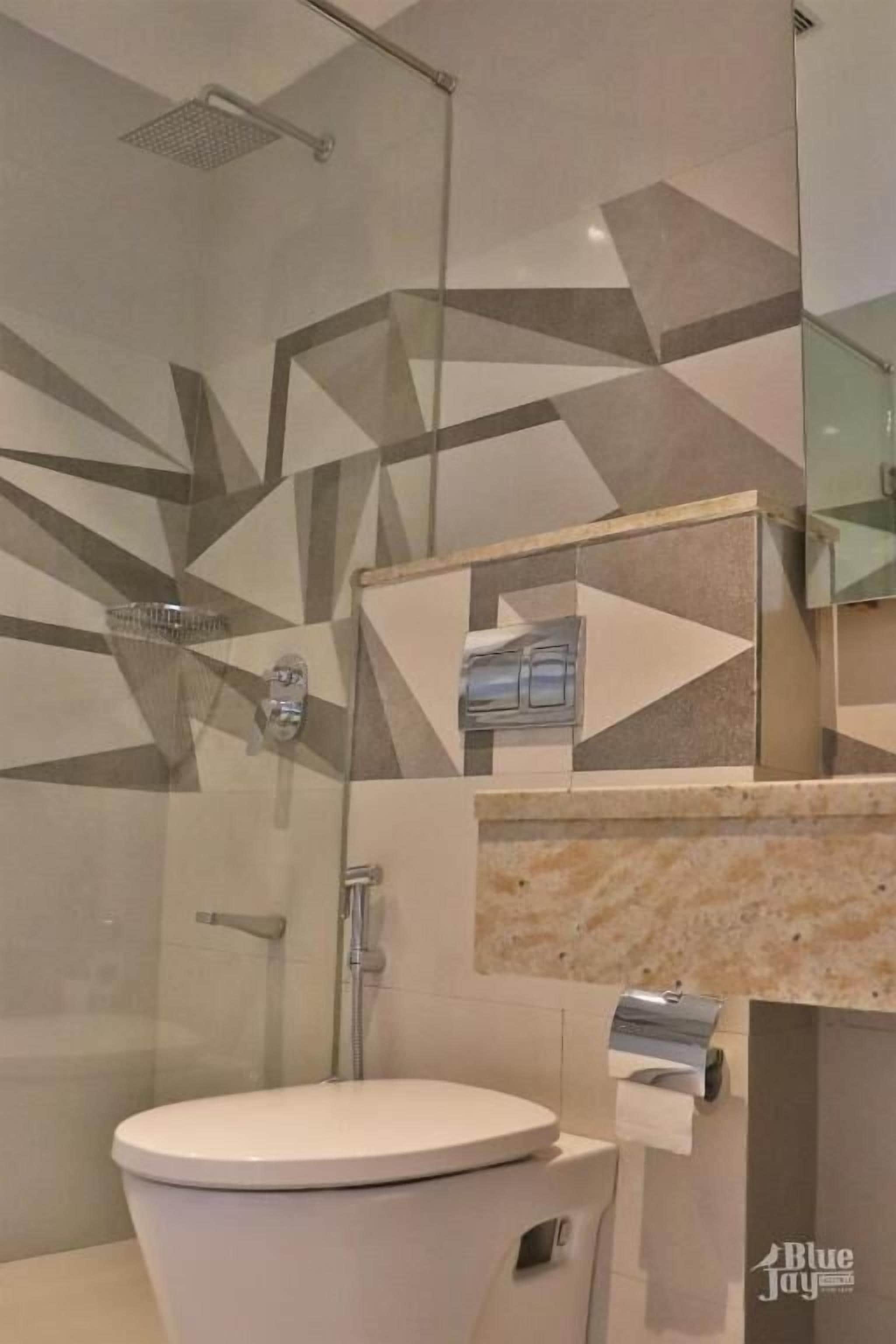 A modern bathroom with a toilet, shower, and a mirror with a towel dispenser.