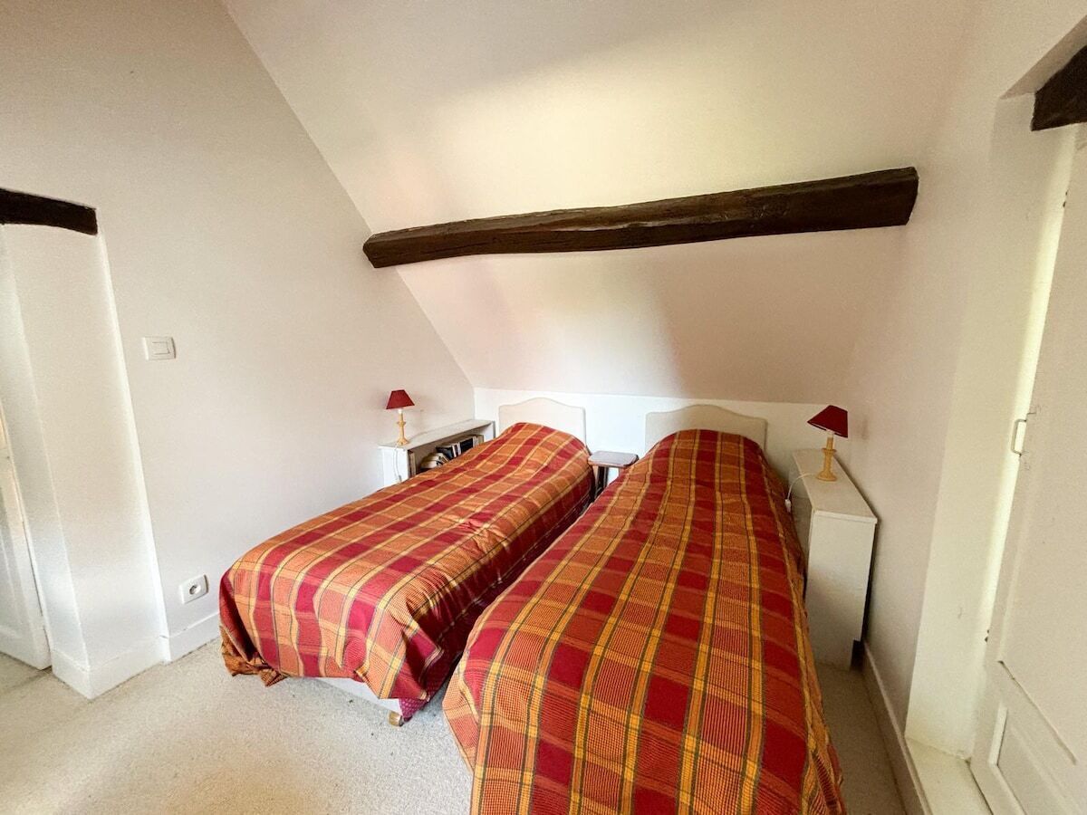Cinquième chambre avec deux lits simples, lampes de chevet, volets