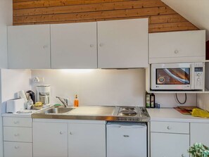 A modern kitchen with white cabinets, a built-in microwave, a stove, and a dishwasher.