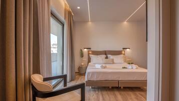 Un dormitorio moderno con una cama grande, lámparas de noche y vistas al exterior a través de una ventana con cortinas.