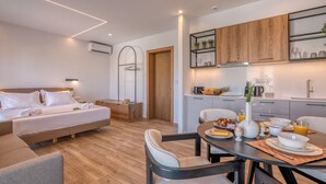 A modern hotel room with a bed, a dining area with breakfast, and a kitchen. - kiwi butique studios (Kissamos)