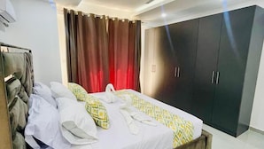 Een moderne slaapkamer met een bed, een plafondventilator en een kledingkast.