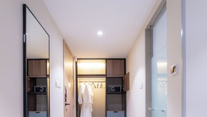 A modern hallway with a mirrored wardrobe, a hanging robe, and a microwave. - The Skye Phnom Penh Hotel & Apartments (Phnom Penh)