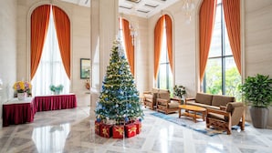 A spacious lobby with a large Christmas tree, elegant furniture, and large windows with draped curtains. - The Skye Phnom Penh Hotel & Apartments (Phnom Penh)
