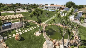 A landscaped garden with a hot tub, palm trees, and a pool area. - Flor de Lis - VIP Properties by Interhome (Paderne)