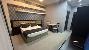 A modern hotel room with a large bed, a desk, and a TV. - Raymond Hotel (Baku)