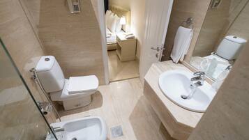 Un baño moderno con inodoro, bidé, lavabo y ducha.