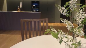 A modern kitchen with a central island, wooden chairs, and a vase with white flowers. - Panoramic view near Gbg and nature (Västra Götalands län)